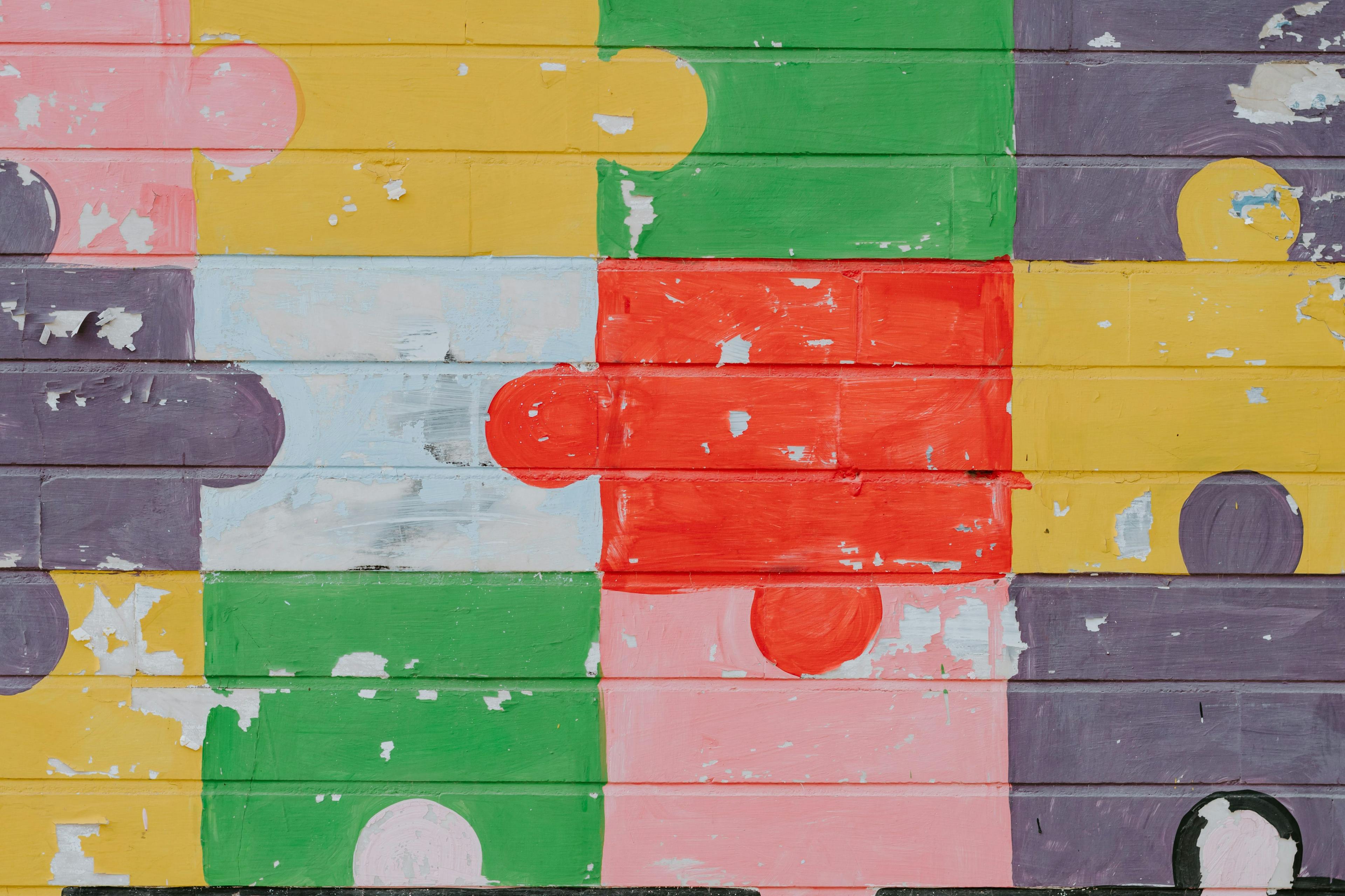 Concrete wall painted with large coloured puzzle pieces